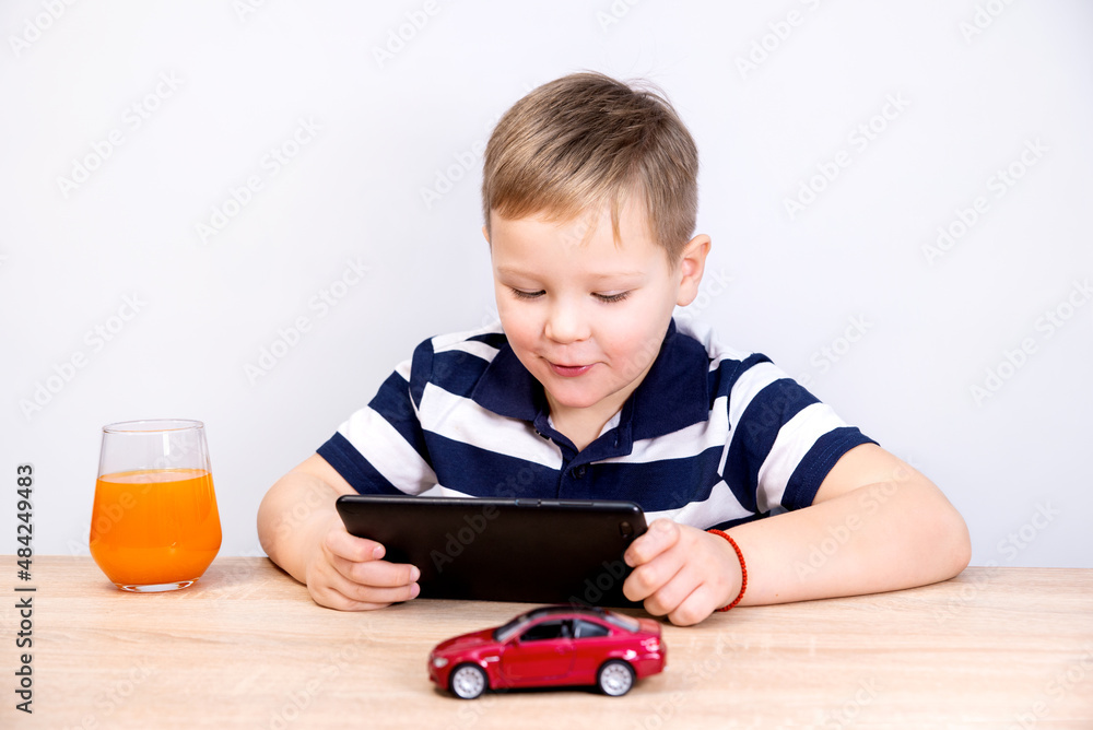 The boy communicates via video link through a tablet. White background, isolated. Copy space The boy communicates via video link through a tablet. White background, isolated. Copy space