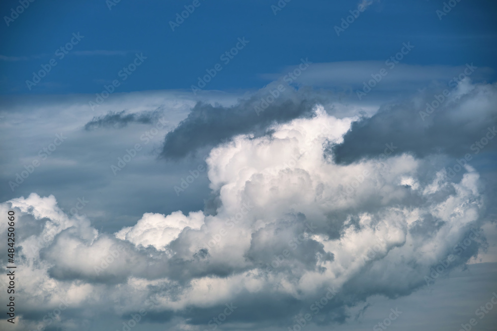 Bright landscape of white puffy cumulus clouds on blue clear sky