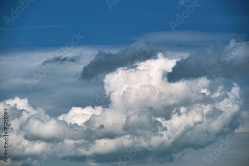 Bright landscape of white puffy cumulus clouds on blue clear sky