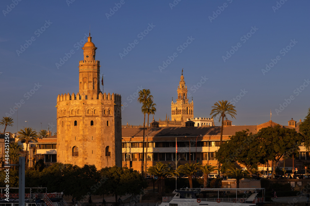 The skyline of Seville with a view on the iconic golden tower on the quayside of the rivier Guadalquivir and in the distance the Giralda tower during the golden hour