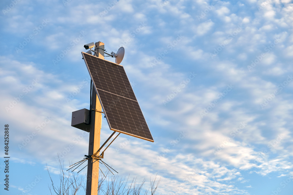 Obraz premium Solar photovoltaic panels mounted on city street pole for electricity supply of streetlights and surveillance cameras