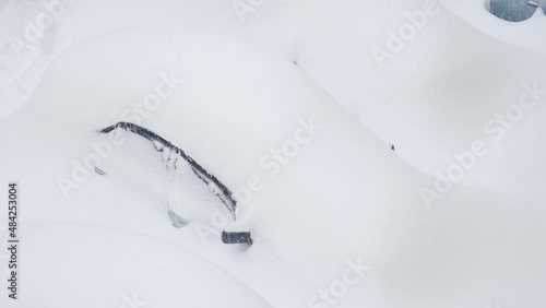 Car burried under deep snow. Outdoor parking after heavy snowfall storm
