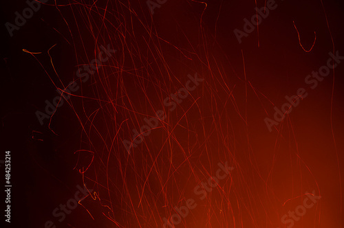 Red sparks of fire from a bonfire with a black background