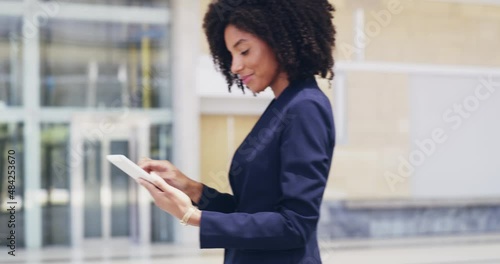 Young hispanic businesswoman with an afro smiling happy nodding in approval holding and using a digital tablet at work. 