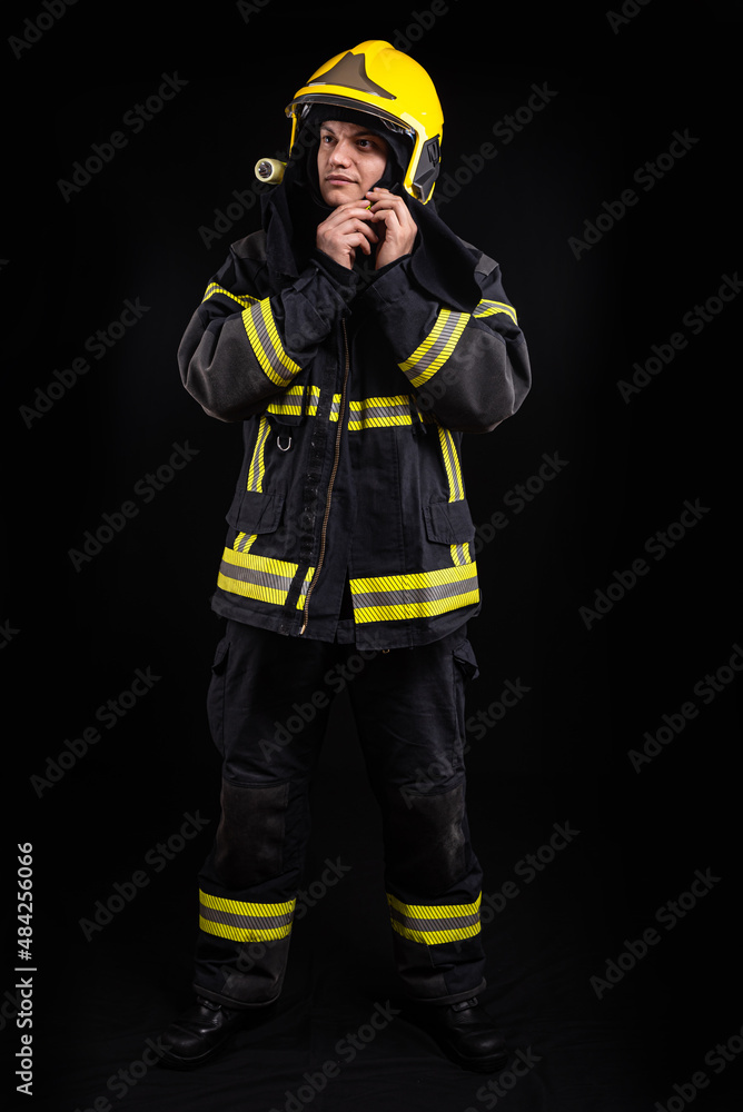 Firefighter in full firefighting gear on a black background Firefighter in full firefighting gear on a black background