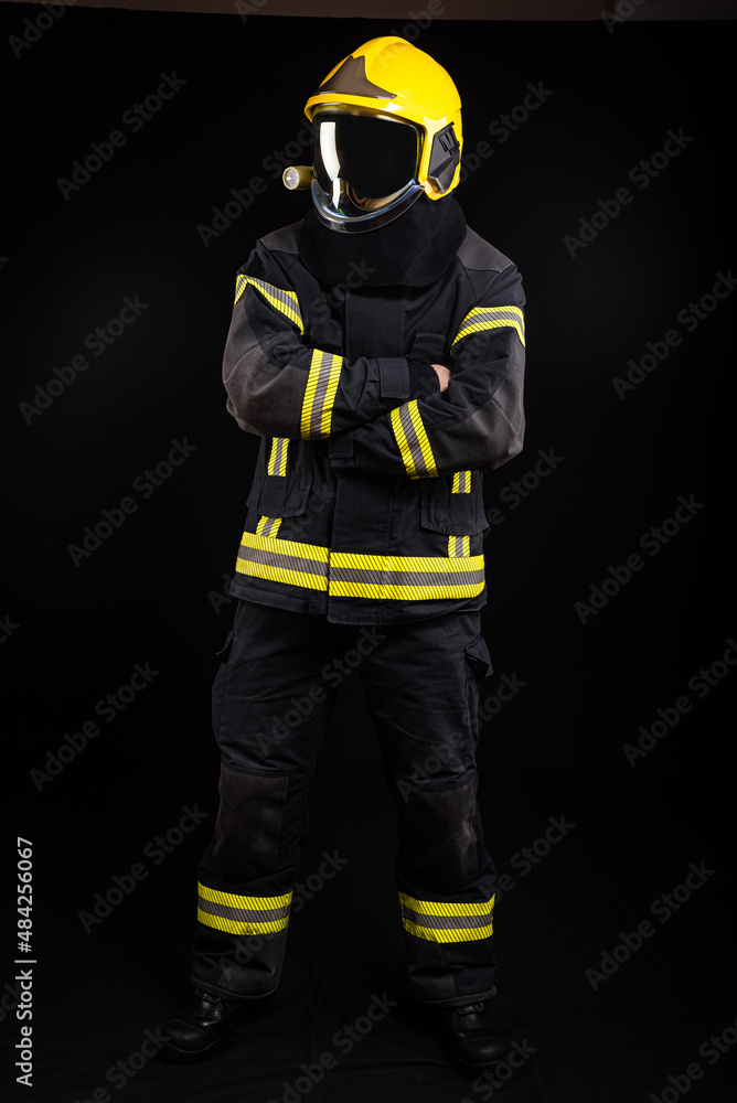 Firefighter in full firefighting gear on a black background