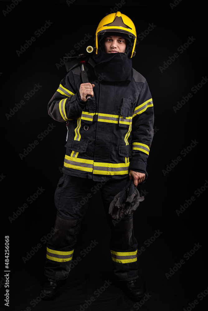 Firefighter in full firefighting gear on a black background Firefighter in full firefighting gear on a black background