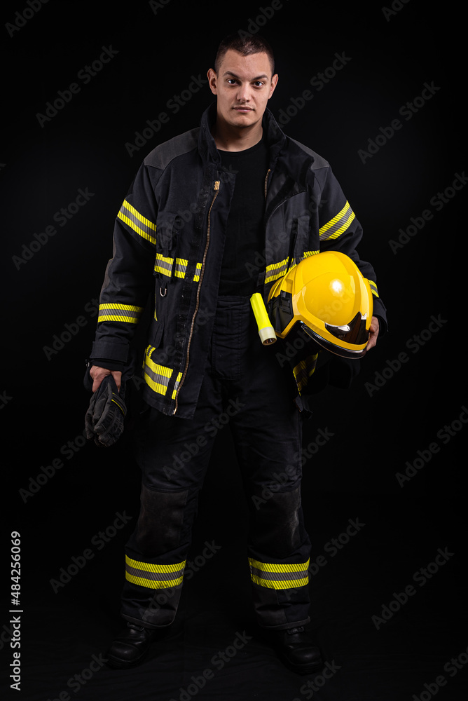 Firefighter in full firefighting gear on a black background Firefighter in full firefighting gear on a black background