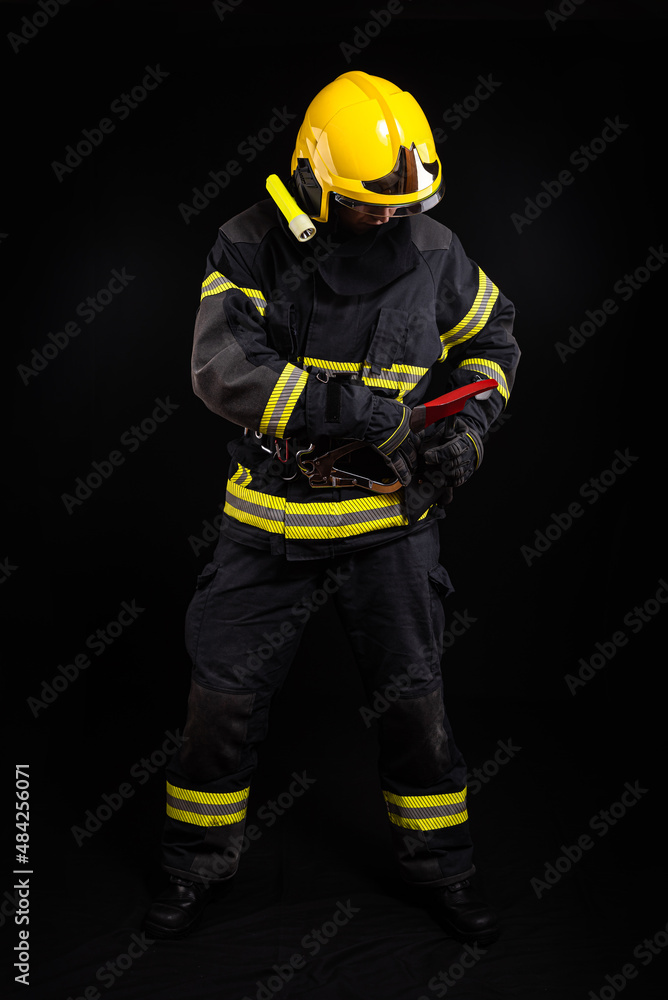 Firefighter in full firefighting gear on a black background Firefighter in full firefighting gear on a black background