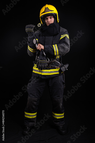 Firefighter in full firefighting gear on a black background