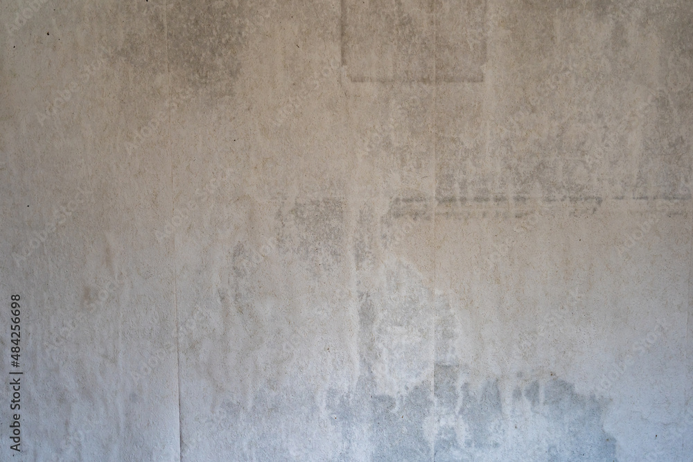 Obraz premium Old dirty wall paper backdrop. Weathered background texture of a damaged and wet material. Interior design of a vintage room. Wavy surface of the wall. Dirt stains and spots on the inner wall.