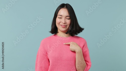 Surprised young woman of Asian ethnicity 20s wears pink shirt look camera point fingers herself ask say who me no thanks i do not need it isolated on plain pastel light blue background studio portrait