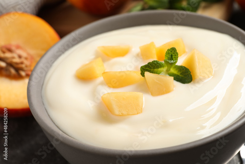 Delicious yogurt with fresh peach and mint in bowl, closeup © New Africa