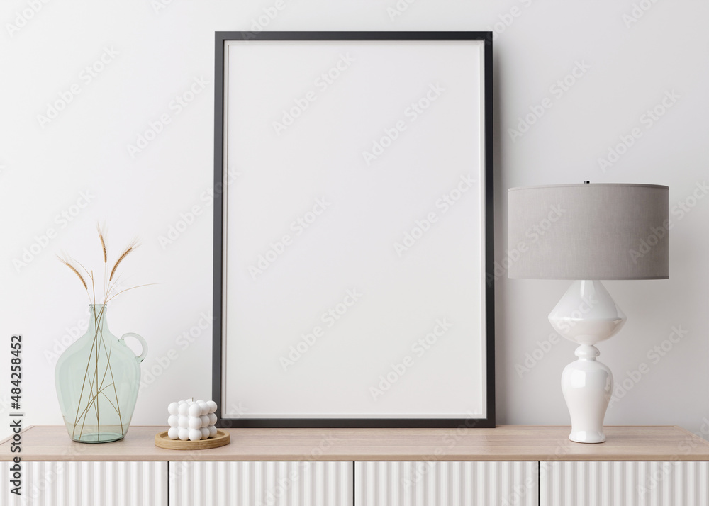 Empty vertical picture frame on white wall in modern living room. Mock up interior in contemporary style. Free space for picture, poster. Console, lamp, glass vase with grass, candle. 3D rendering.