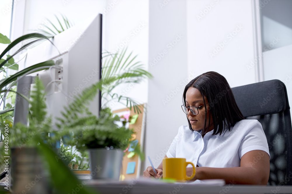 Black lady office worker concentrated on work, writing documents information, sit alone in bright cozy modern office, use pc computer, dressed in formal clothes. success, work, business, management Black lady office worker concentrated on work, writing documents information, sit alone in bright cozy modern office, use pc computer, dressed in formal clothes. success, work, business, management