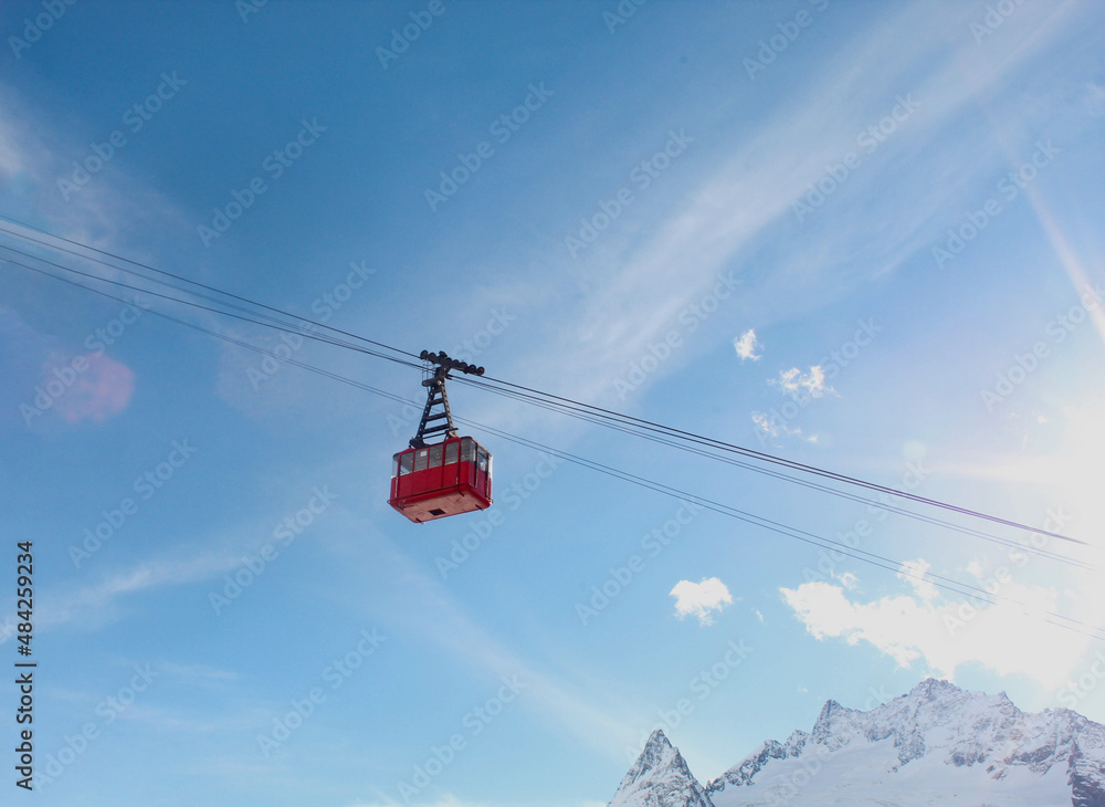 Fototapeta premium Cable car to the top of Dombay-Ulgen mountain. Caucasian ridge. Cableway to the mountains. North Caucasus. Snow-capped mountains of the Caucasus.
