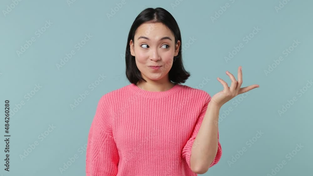 Secret young woman of Asian ethnicity 20s wears pink shirt look aside say be quiet shhh gesture close her mouth lock and throw away key isolated on plain pastel light blue background studio portrait Secret young woman of Asian ethnicity 20s wears pink shirt look aside say be quiet shhh gesture close her mouth lock and throw away key isolated on plain pastel light blue background studio portrait