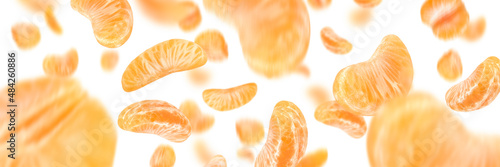 Falling mandarin slices on a white isolated background. Citrus fruit background, yellow tangerine slices with selective focus
