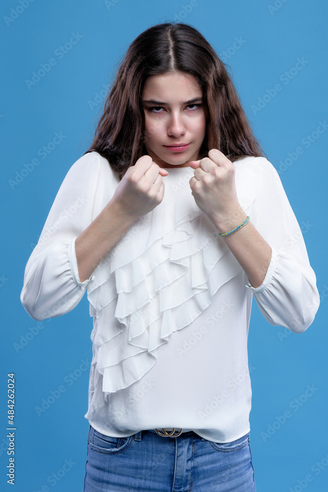 Angry teenage girl clutching her fists, furious and enraged, ready to ...