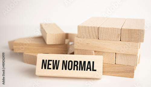 The what NEW NORMAL is written on one of the many scattered wooden blocks
