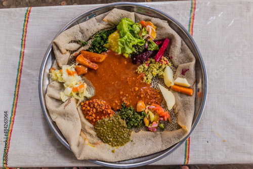 Typical meal in Ethiopia - Beyainatu. Meaing bit of everything. Mix of vegetables and stews on injera flatbread. photo