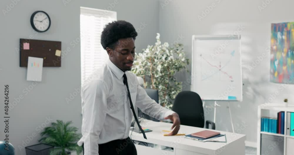 Man with afro dances in the middle of the company office, practicing new moves before the event, happy to win a contract, good news, employee got a promotion, ends work earlier, higher pay Man with afro dances in the middle of the company office, practicing new moves before the event, happy to win a contract, good news, employee got a promotion, ends work earlier, higher pay