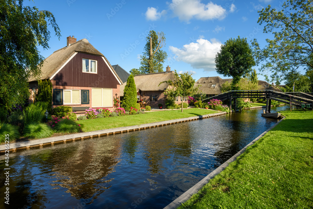 Houses on water canal in Giethoorn village, Netherlands Houses on water canal in Giethoorn village, Netherlands