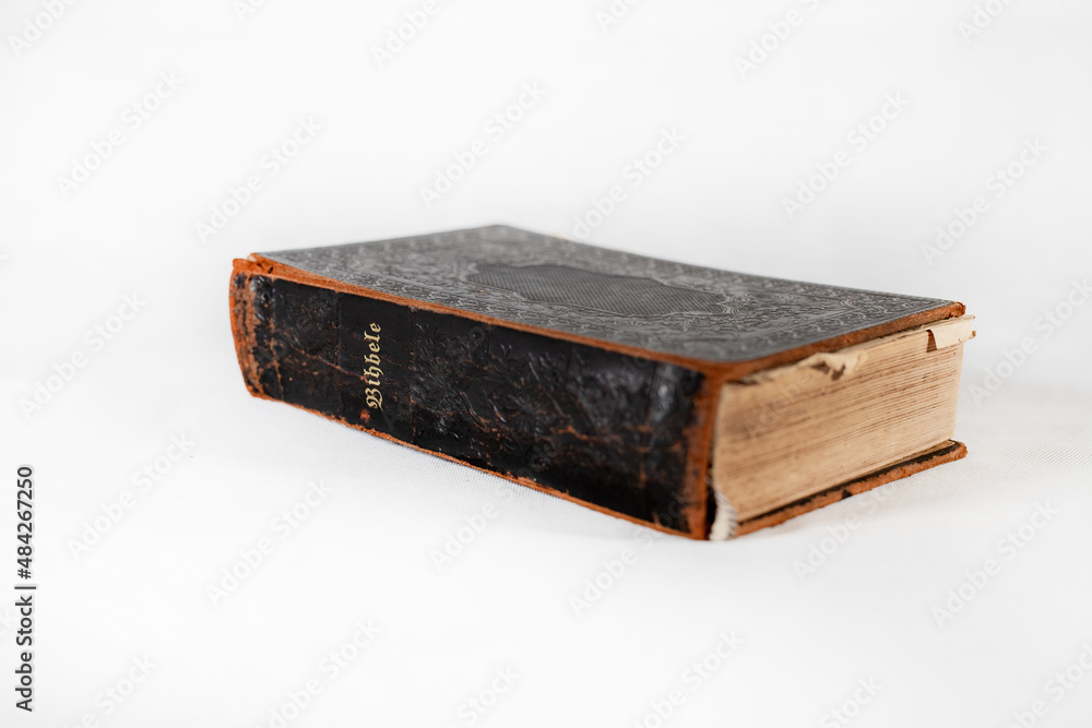 100 years old retro holy bible book with hard covers and dark color on white background 100 years old retro holy bible book with hard covers and dark color on white background