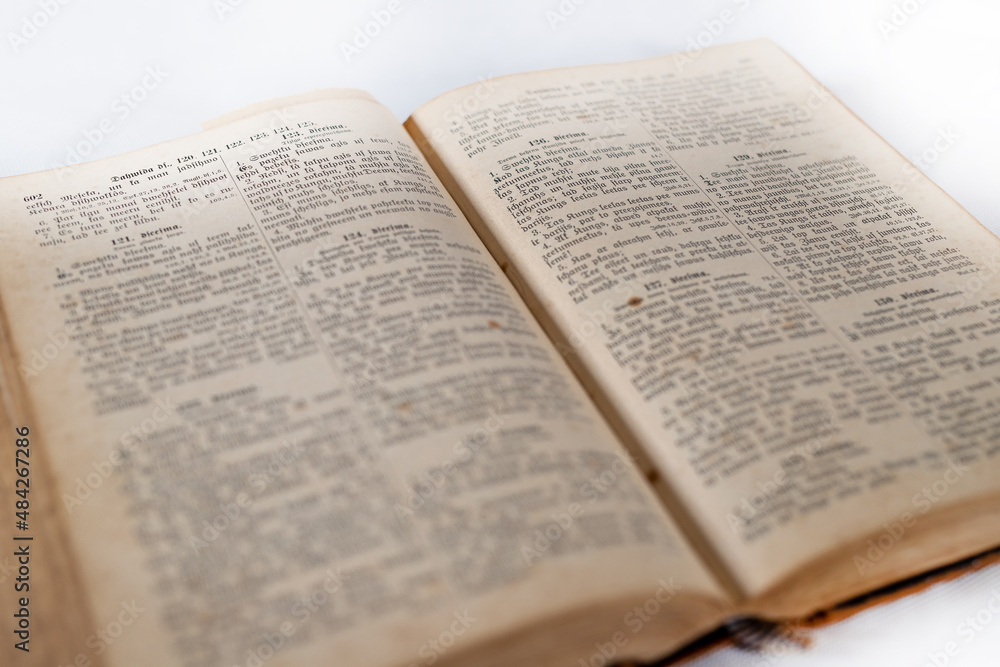 100 years retro old holy bible book opened with visible text on white background 100 years retro old holy bible book opened with visible text on white background