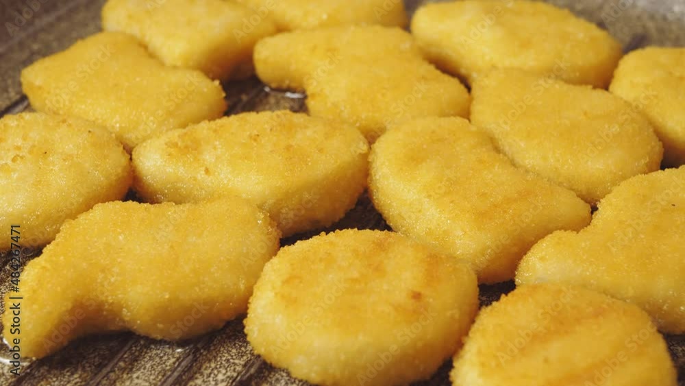 crispy nuggets are fried in a pan in oil. close-up crispy nuggets are fried in a pan in oil. close-up