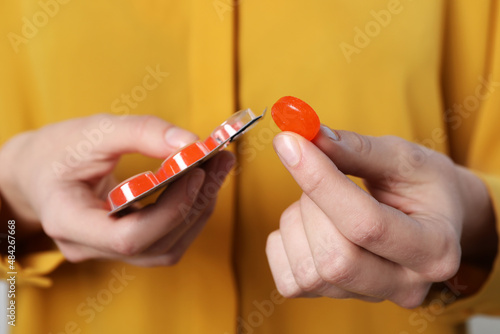Obraz na plátně Woman taking cough drop from blister, closeup