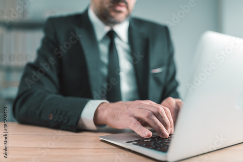 Business person typing laptop computer keyboard in company office