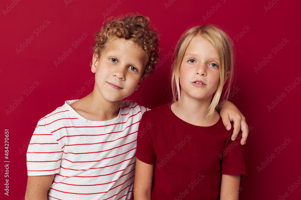 Small children emotions stand side by side in everyday clothes red background unaltered Small children emotions stand side by side in everyday clothes red background unaltered