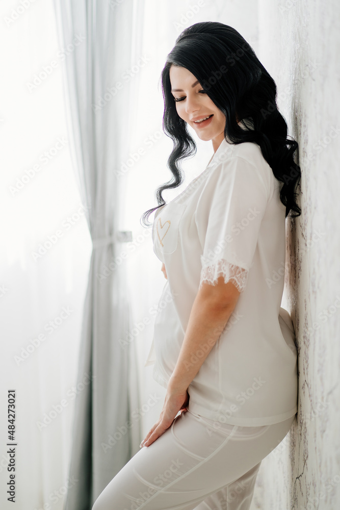 beautiful pregnant bride brunette in white pajamas. beautiful pregnant bride brunette in white pajamas.
