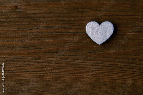 Silver wooden heart on a dark wooden background