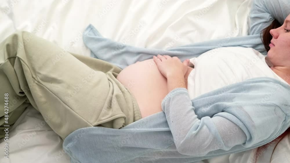 Top view Pregnant expectant mother caressing her belly. Woman hands touching her tummy, waiting child, lying on bed Preparation for childbirth, Girl big belly advanced pregnancy. Top view Pregnant expectant mother caressing her belly. Woman hands touching her tummy, waiting child, lying on bed Preparation for childbirth, Girl big belly advanced pregnancy.