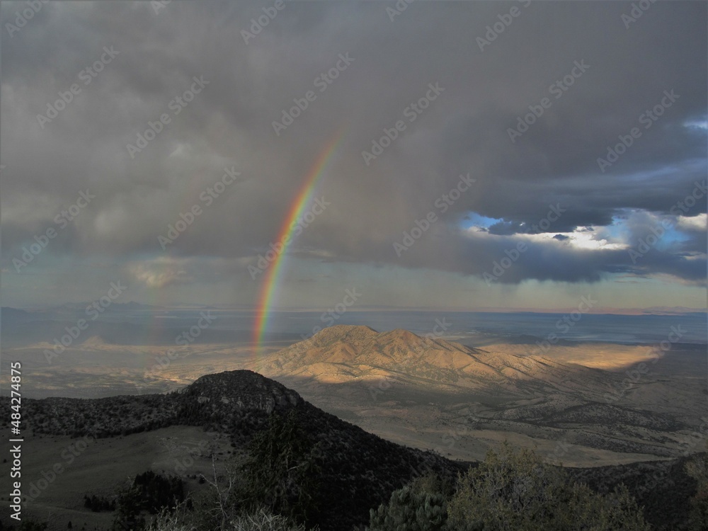 A rainbow shines in a storm over Nevada’s Goshute Mountains