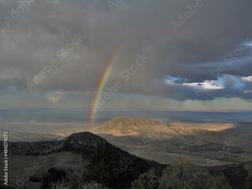 A rainbow shines in a storm over Nevada’s Goshute Mountains