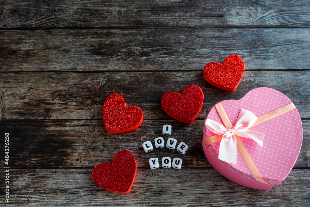 Fototapeta premium Pink Valentine's Day gift box on wooden table with I Love You text and copy space