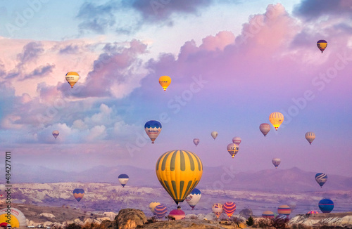 Bright multi-colored hot air balloons flying in sunsrise sky Cappadocia