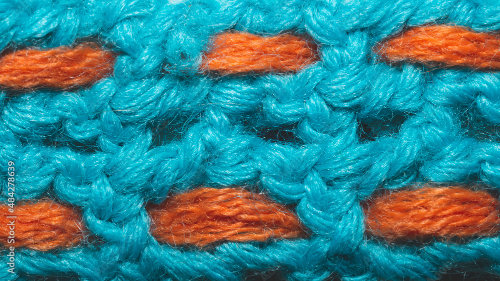 Blue woolen fabric with orange threads. knitted background