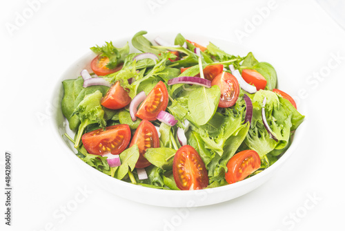 Summre green salad in white bowl plate on grey table