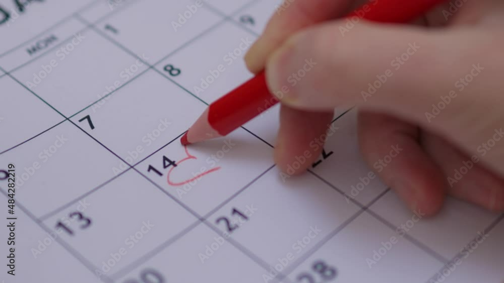 happy Valentine's Day concept: hand writing note shape of heart with red pencil 14 February date month planner paper calendar. celebrating love holiday. note reminding handwritings close-up view happy Valentine's Day concept: hand writing note shape of heart with red pencil 14 February date month planner paper calendar. celebrating love holiday. note reminding handwritings close-up view