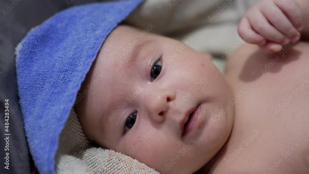 Caucasian beautiful child lying naked covered in towel. Adorable baby resting on bed after being washed. Close up. Caucasian beautiful child lying naked covered in towel. Adorable baby resting on bed after being washed. Close up.