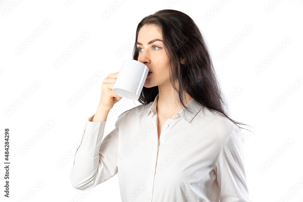 Business woman drinking from a mug wearing a white shirt. Isolated on white background. 20-22 years old. White european woman. Business woman drinking from a mug wearing a white shirt. Isolated on white background. 20-22 years old. White european woman.