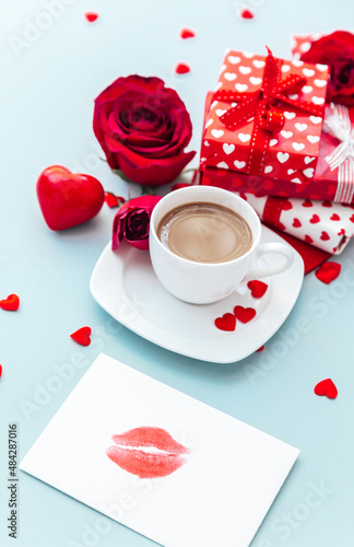 White cup of coffee with gift and roses. morning breakfast. Holiday background. Greeting card. Valentines Womans Mothers day. Top view. Flat lay