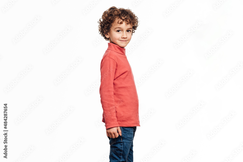 Young boy looking at camera and smiling while posing over an isolated white background. Childhood concept. Young boy looking at camera and smiling while posing over an isolated white background. Childhood concept.