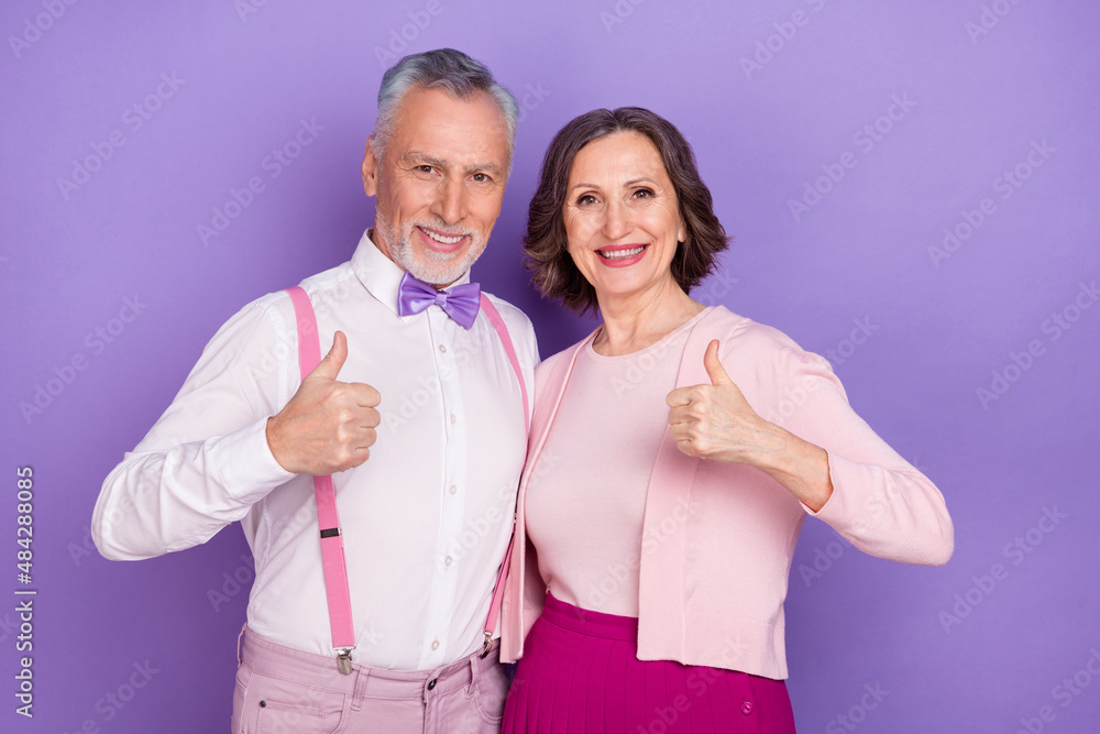 Photo of friendly elderly two partners hands fingers demonstrate thumb up isolated on purple color background Photo of friendly elderly two partners hands fingers demonstrate thumb up isolated on purple color background