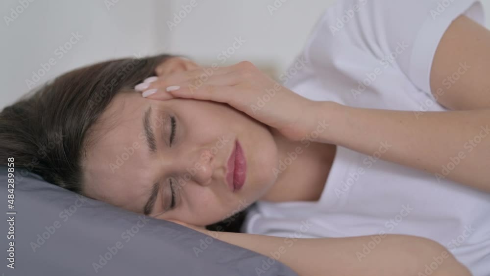 Woman having Headache while Sleeping in Bed Woman having Headache while Sleeping in Bed
