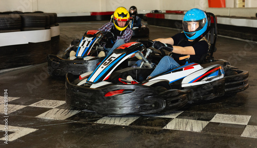 Young people driving sport cars for karting in a circuit lap in sport club